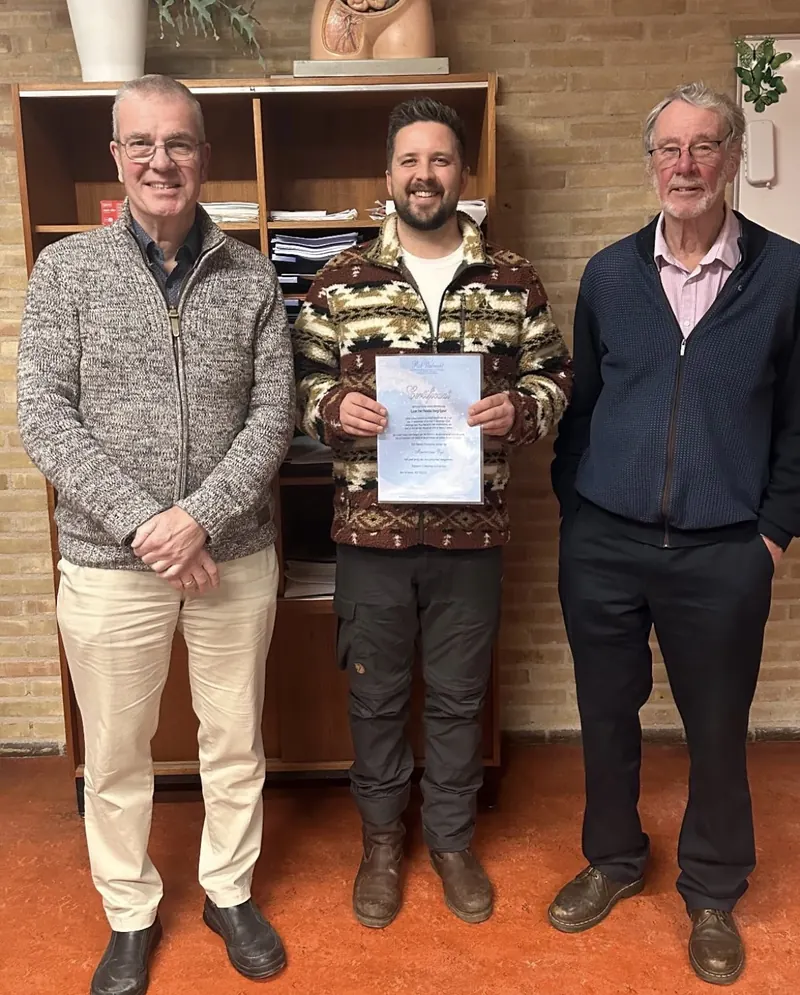 Maurice met zijn certificaat, tussen twee cursusleiders